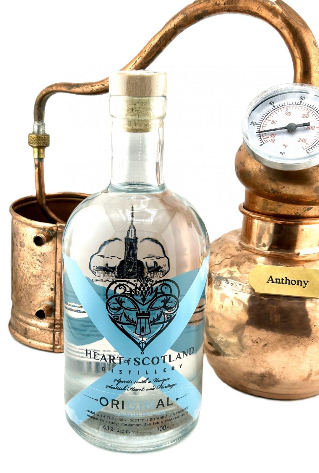 Heart of Scotland Gin bottle beside a small test still, showcasing the traditional Scottish craft distillation process for premium small-batch gin.